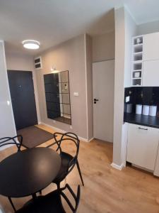 een kamer met een tafel en stoelen en een keuken bij Apartament Łąkoszyn Kutno in Kutno