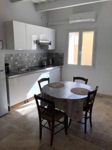 eine Küche mit einem Tisch und Stühlen in einer Küche in der Unterkunft Au coeur de la Venise Povençale in LʼIsle-sur-la-Sorgue