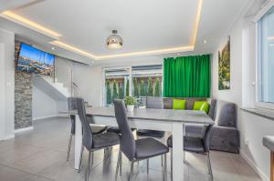 a dining room with a table and chairs at Domki apartamentowe Na wrzosach in Jastrzębia Góra