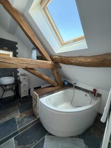een badkamer met een bad en een dakraam bij Sur Les Roches in Dracy-lès-Couches