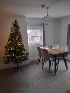 アイアンブリッジにあるIronbridge town apartmentのテーブルと椅子付きの部屋のクリスマスツリー