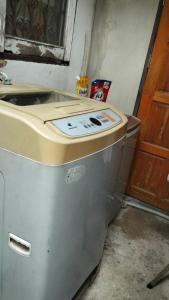 a metal refrigerator in a room with a door at Palmhouse studio room in Bang Khen