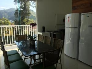 a kitchen with a dining table and a refrigerator at DiPietro Home in Ubatuba