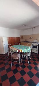 a kitchen with a table and chairs on a checkered floor at Departamento Silvi in Jesús María