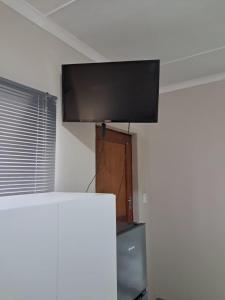 a flat screen tv sitting on top of a wall at Klein Karoo Wegbreek in Oudtshoorn
