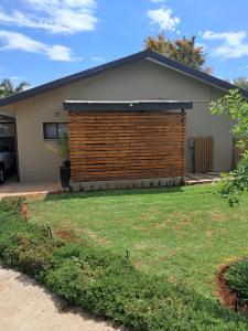 a house with a wooden fence in a yard at Klein Karoo Wegbreek in Oudtshoorn