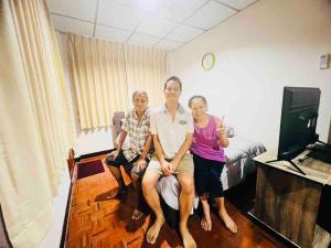 eine Gruppe von drei Personen, die in einem Zimmer sitzen in der Unterkunft Palmhouse studio room in Bang Khen