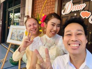 two men and a woman posing for a picture at Palmhouse studio room in Bang Khen