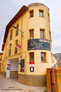 Un edificio con un cartel al costado. en Hostal Marcela Berge, en Berge