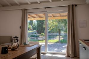 a kitchen with a sliding glass door to a yard at Il giardino di Magliano in Magliano in Toscana