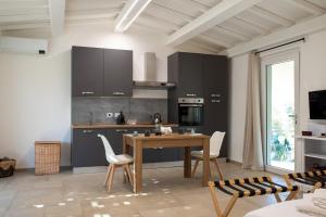 a kitchen with a wooden table and white chairs at Il giardino di Magliano in Magliano in Toscana