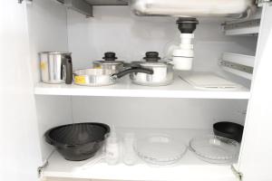 a shelf with pots and pans in a kitchen at Apartamento novo com ar condicionado e garagem in São Lourenço +10 photos