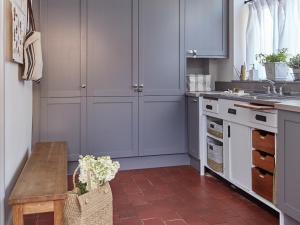 ランゴレンにあるGreen Acresのキッチン(青いキャビネット、木製テーブル付)
