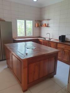 a kitchen with a large wooden island in the middle at Maya, Entire Apartment, Mbour, 3 air-conditioned bedrooms in Mbour