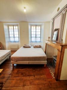 a bedroom with a bed and two windows at Maison avec jardin aux Cabannes - Ariège in Les Cabannes