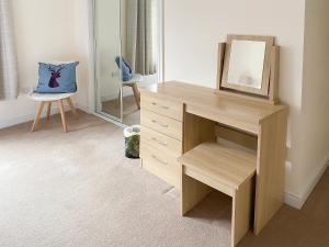 einen Schreibtisch mit einem Spiegel und einem Stuhl in einem Zimmer in der Unterkunft Dalnafeidh Beag - Cottage in Portnacroish