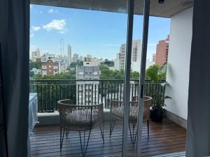 a balcony with chairs and a view of a city at Departamento Estudio Deluxe in La Plata