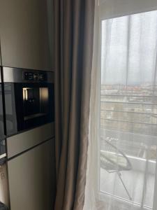 Una cocina con ventana, una silla y un microondas. en Перлина Франківська, en Ivano-Frankivsk