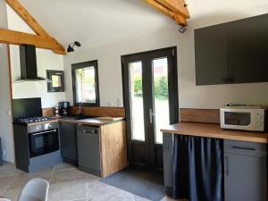 una cucina con fornelli e microonde di Le gîte Normand a Saint-Vaast-dʼÉquiqueville Altre 7 foto