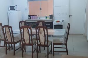 a kitchen with a dining room table and chairs at Sobrado 2 amplo e confortável em condomínio in Corumbá +20 photos
