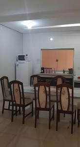 a room with a table and chairs and a kitchen at Sobrado 2 amplo e confortável em condomínio in Corumbá