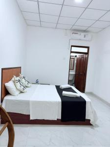 a bedroom with a large bed with white sheets and pillows at Sigiri Sihina Villa in Inamaluwa