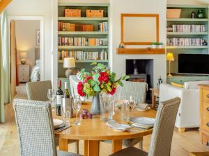 a dining room with a table with a vase of flowers at Windover Barn in Slinfold