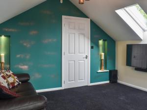 a room with a white door and a blue wall at Moorhens in Herstmonceux +28 photos