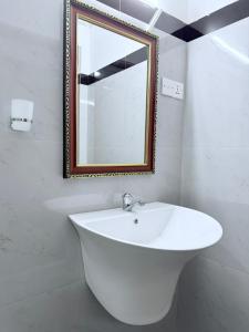 a bathroom with a white sink and a mirror at Sigiri Sihina Villa in Inamaluwa