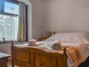ein Schlafzimmer mit einem Holzbett mit Handtüchern darauf in der Unterkunft Melrose in Clitheroe + 19 Fotos
