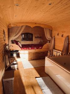 a room with a bed and a tub in a cabin at La champ être in Neuville-sur-Sarthe