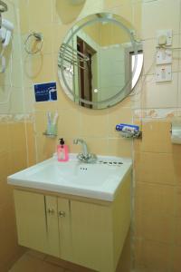 une salle de bain avec un lavabo et un miroir dans l'établissement فندق جواد الحرم الفندقية, à Az Zahrāʼ