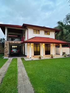 a house with a green lawn in front of it at Paradise Villa in Kandana