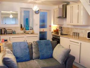 a living room with a couch in a kitchen at Salty Cottage in Newlyn +29 photos