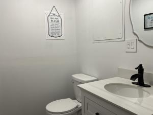 a white bathroom with a toilet and a sink at 20 Mile Bay Lake View 4 Bedroom Public Beach Pet Friendly fee applies in Tuftonboro