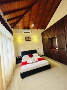 a bedroom with a large bed with wooden cabinets at Paradise Villa in Kandana