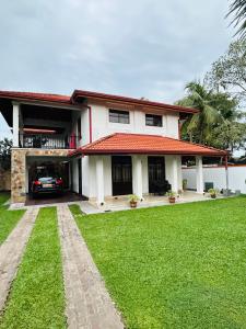 a house with a car parked in front of it at Paradise Villa in Kandana