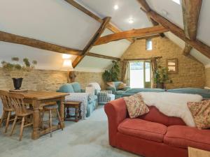 DaglingworthにあるFlowers Barnの赤いソファとテーブルのあるリビングルーム