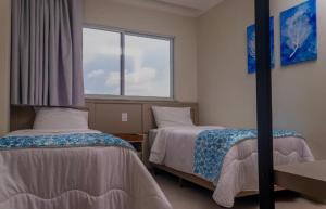 a room with two beds and a window at Apartamento Aqualand Salinas in Salinópolis