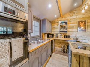 a large kitchen with wooden walls and wooden counters at The Lodge - Uk50409 in Bisterne