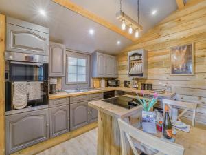 a large kitchen with wooden walls and wooden counters at The Lodge - Uk50409 in Bisterne