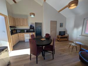 eine Küche und ein Esszimmer mit Tisch und Stühlen in der Unterkunft Le Renard des Vosges in La Croix-aux-Mines