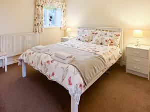 a bedroom with a bed with towels on it at Ty Main Cottage in Newborough