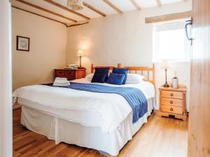 a bedroom with a large white bed with blue pillows at The Parlour - Uk6717 in Lydstep