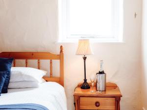 a lamp on a night stand next to a bed at The Parlour - Uk6717 in Lydstep