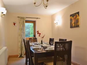 a dining room with a table and chairs and a window at Shippon Cottage - E4299A in Halston