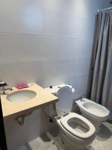 a bathroom with a toilet and a sink at Departamento Estudio Deluxe in La Plata +17 photos