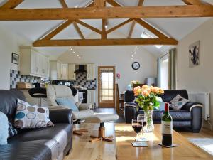 een woonkamer met een bank en een tafel met een fles wijn bij Llanlliwe Cottage in Henllan Amgoed