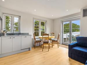 eine Küche und ein Esszimmer mit einem Tisch und einem blauen Sofa in der Unterkunft Rogestons House in Nolton