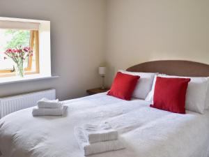 a bedroom with a large white bed with red pillows at The Granary in Pendleton